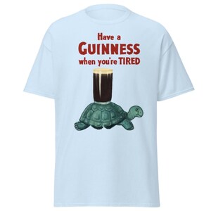 May include: A light blue t-shirt with the text "Have a GUINNESS when you're TIRED" in red. A cartoon turtle is carrying a glass of Guinness.