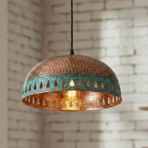 May include: A copper pendant light with a hammered texture and a turquoise band. The light has a teardrop pattern around the bottom edge and a visible lightbulb.