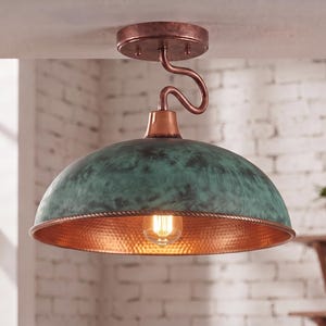 May include: A ceiling-mounted pendant light featuring a dome-shaped shade with a weathered teal and green patina finish. The interior of the shade has a hammered copper texture, and the fixture includes a curved copper arm and a single light bulb.