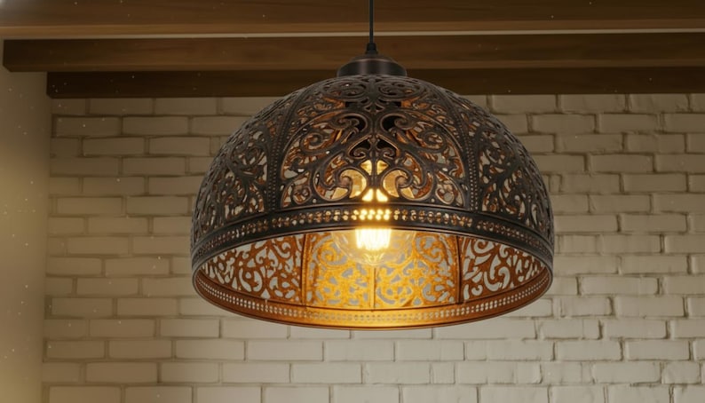 K&ouml;nnte beinhalten: Verzierte, kuppelf&ouml;rmige Pendelleuchte mit Bronze-Finish. Das filigrane, offene Design l&auml;sst das Licht durchscheinen und beleuchtet die warm get&ouml;nte Gl&uuml;hbirne im Inneren. Die Leuchte h&auml;ngt an einem einzelnen Kabel.