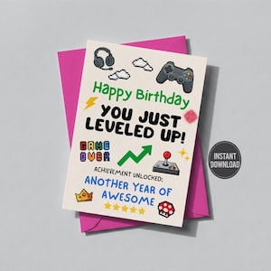 May include: A birthday card with a pink envelope. The card features gaming-themed graphics, including a controller, headset, and text that reads "Happy Birthday, You Just Leveled Up!" and "Achievement Unlocked: Another Year of Awesome."