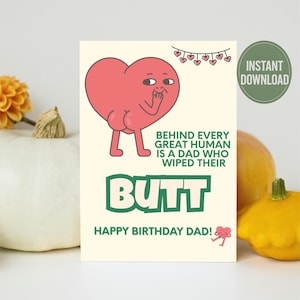 Può includere: Un biglietto di auguri con un personaggio a forma di cuore dei cartoni animati. Il testo sul biglietto recita: "Dietro ogni grande essere umano c'è un papà che gli ha pulito il sedere. Buon compleanno papà!"