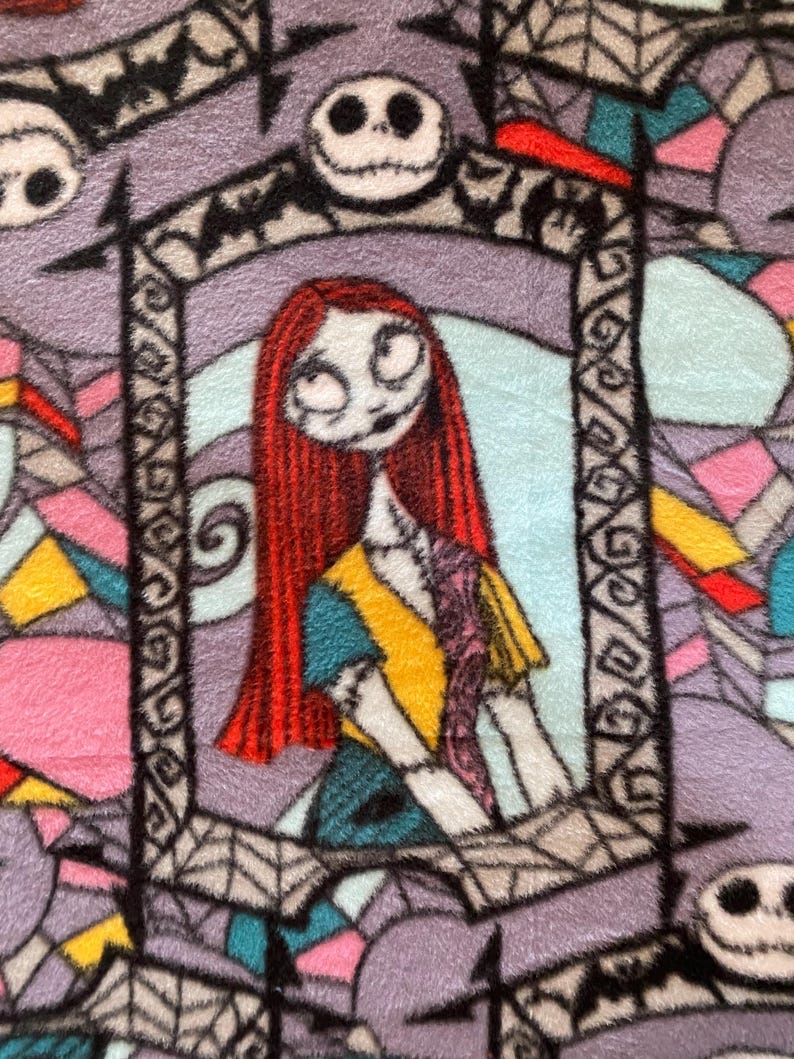 Puede incluir: Una tela colorida con un patr&oacute;n repetido de Jack Skellington y Sally de Pesadilla Antes de Navidad. La tela presenta un fondo morado con acentos negros, blancos, rojos, amarillos, azules y rosas.