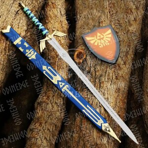 May include: A sword, scabbard, and shield set. The sword has a silver blade, gold hilt, and a blue and green handle. The scabbard is blue with gold accents. The shield is orange with a gold emblem.