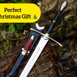 Könnte beinhalten: Ein silbernes und schwarzes Schwert mit goldenem Knauf und einer rot-schwarzen Scheide. Der Text "Perfect Christmas Gift" wird auf einem gelben Banner angezeigt.