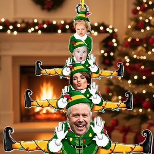 May include: A Christmas tree ornament featuring a family dressed as elves. The ornament has a yellow and green color scheme, with each family member's face visible. The ornament is decorated with Christmas lights and is hanging from a gold loop.