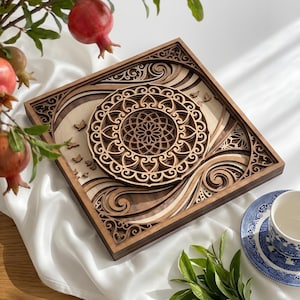 May include: A square, multi-layered wooden wall art piece featuring intricate laser-cut patterns. The design includes a central circular mandala motif surrounded by flowing, wave-like shapes and small bird silhouettes, crafted from light and dark wood.