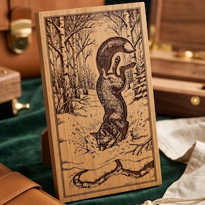 May include: A rectangular wooden plaque featuring a laser-engraved illustration of a fox diving headfirst into snow within a forest setting. The artwork depicts the fox with its tail raised, surrounded by bare trees and snowy ground.