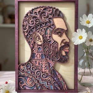 Könnte beinhalten: Ein mehrschichtiges Wandkunstwerk aus Holz, das ein Profilporträt einer Person mit Bart und komplizierten, lasergeschnittenen geometrischen und wirbelnden Mustern zeigt. Das Kunstwerk ist in dunkelviolettes Holz gefasst und verwendet Rosa-, Blau- und Naturholztöne.