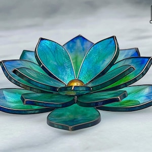 Puede incluir: Escultura artesanal de flor de loto en vidrio. Los pétalos son de tonos turquesa, azul y verde, con un centro dorado. Los bordes están delineados en metal color cobre. Una pieza de arte decorativa.