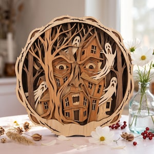 May include: A circular layered wooden wall art piece featuring a carved face integrated into a forest scene with houses and three ghosts. The design uses various shades of natural wood to create depth, depicting a haunted woodland landscape.