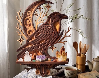May include: A layered wooden wall art piece featuring a raven perched before a crescent moon and star cutouts. The base shelf displays clear quartz, amethyst, and citrine crystals. The artwork is crafted with dark and light wood tones.