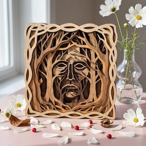 May include: A square, multi-layered wooden wall art piece featuring a carved face integrated into a forest of tree branches. The design is enclosed within a decorative, woven-style border, showcasing intricate depth and natural wood grain tones.