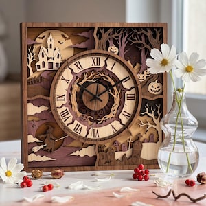 May include: A square wooden wall clock featuring a multi-layered laser-cut design with a haunted house, a witch on a broomstick, a graveyard, and jack-o'-lanterns. The clock face displays Roman numerals and black hands over a dark gear mechanism.