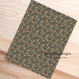 May include: A rectangular sheet with a floral pattern. The design features small yellow, orange, and white flowers with green leaves on a dark background. The text "dandelion designs" and "clay transfer sheets" is visible.