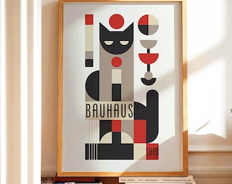 May include: Framed art print featuring a geometric cat design in black, red, gray, and white. The word "BAUHAUS" is printed in a bold font, with the year "1919" below. The artwork is in a light wood frame.