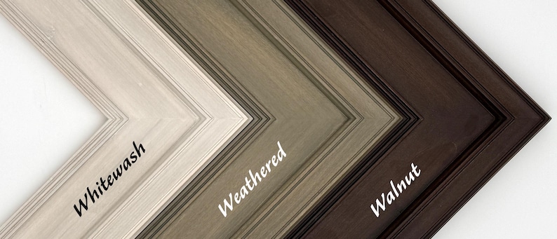 May include: Close-up of three wooden picture frame corners in different finishes: Whitewash, Weathered, and Walnut. The frames are angled, showcasing the varying textures and colors, with the names of each finish written in cursive.