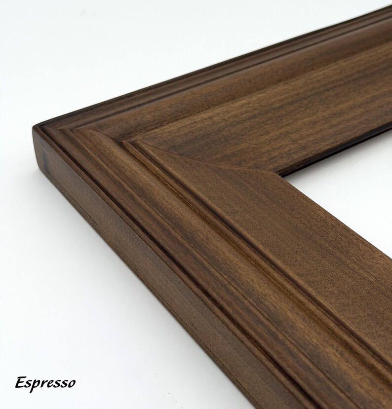 May include: Close-up of a corner of a wooden picture frame in a rich espresso color. The frame has a detailed, grooved design and a beveled edge. The word "Espresso" is printed in the bottom left corner.
