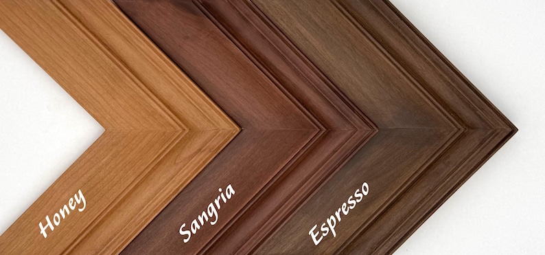 May include: Close-up of three wooden picture frames in shades of honey, sangria, and espresso. The frames are angled, showcasing their detailed molding and color variations. The names of the colors are written on the frames.
