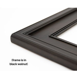 May include: Close-up of a black walnut picture frame corner. The frame has a classic design with a rounded edge and a recessed inner border. The text "(frame is in black walnut)" is visible.