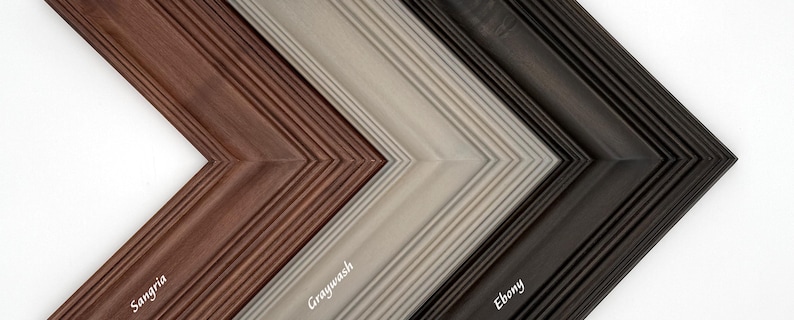 May include: Close-up of four wooden picture frame corners in a chevron pattern. The frames are Sangria, Graywash, and Ebony. Each frame has a grooved texture and the name of the color is printed on the frame in white.
