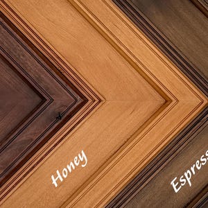 May include: Close-up of three wooden picture frames in a V-shape, showcasing different stain colors. The colors are Sangria, Honey, and Espresso, with the names of the colors written in white script on each frame.