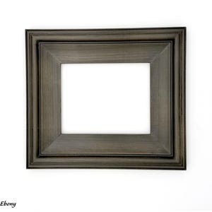 May include: A rectangular ebony-colored picture frame with a white interior. The frame has a layered design and is set against a white background. The word "Ebony" is printed in the lower left corner.