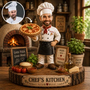 May include: A custom bobblehead figurine of a chef wearing a white uniform, black apron, and toque, holding a pizza. The base is a wood slice labeled CHEF'S KITCHEN, surrounded by miniature bowls of tomatoes, cheese, sauce, a basil plant, and signs.