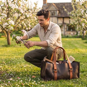 Man pruning trees in garden with large leather tool bag nearby, practical gardening tote and outdoor tool organizer