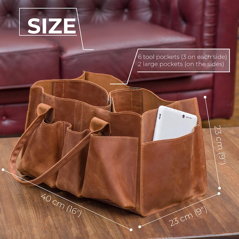 K&ouml;nnte beinhalten: Eine braune Ledertasche mit sechs Werkzeugtaschen und zwei gro&szlig;en Taschen. Die Tasche misst 40 cm in der Breite, 23 cm in der H&ouml;he und 23 cm in der Tiefe.