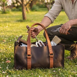 Close-up of leather tool bag handle with stitching, metal rivets and dark brown genuine leather texture