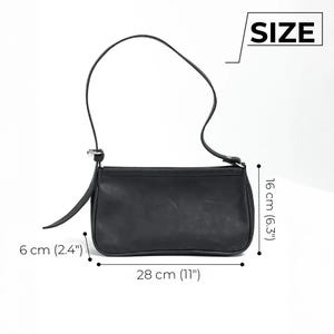 K&ouml;nnte beinhalten: Schwarze Leder-Umh&auml;ngetasche mit langem Riemen. Die Tasche ist 28 cm lang, 16 cm hoch und 6 cm breit. Die Tasche hat eine einfache, rechteckige Form und einen Klappenverschluss.