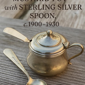 Puede incluir: Antiguo bote de mostaza inglés con cuchara de plata de ley, c.1900-1930. El bote es un pequeño recipiente plateado con tapa y asa. Una cuchara a juego descansa junto a él. El texto de la imagen dice "Antique English Mustard Pot with Sterling Silver Spoon, c.1900-1930."