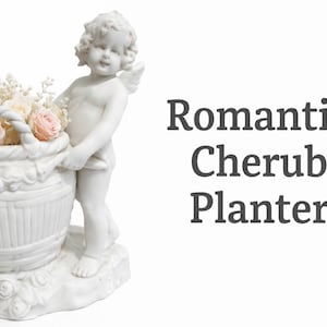 Könnte beinhalten: Ein weißer Cherub-Blumentopf, der einen Korb mit rosa und cremefarbenen Rosen hält. Der Pflanztopf hat ein detailliertes Design und der Text "Romantic Cherub Planter" wird angezeigt.