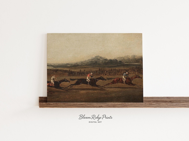 K&ouml;nnte beinhalten: Vintage Kunstdruck eines Pferderennens. Das Kunstwerk zeigt drei Pferde mit Jockeys auf einem Feld, mit einer Menschenmenge im Hintergrund. Die Farbpalette ist ged&auml;mpft, mit Braun-, Beige- und Gr&uuml;nt&ouml;nen.