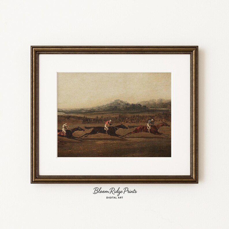 K&ouml;nnte beinhalten: Gerahmter Vintage-Druck eines Pferderennens. Das Kunstwerk zeigt Jockeys auf Pferden, die &uuml;ber ein Feld rennen, mit einer Zuschauermenge im Hintergrund. Der Rahmen ist dunkelgoldfarben und verziert. Der Text "Bloom Ridge Prints" befindet sich unten.