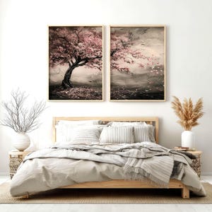a serene bedroom scene with a large bed, a nightstand, and two framed paintings of trees with pink blossoms hanging on the wall above the bed.