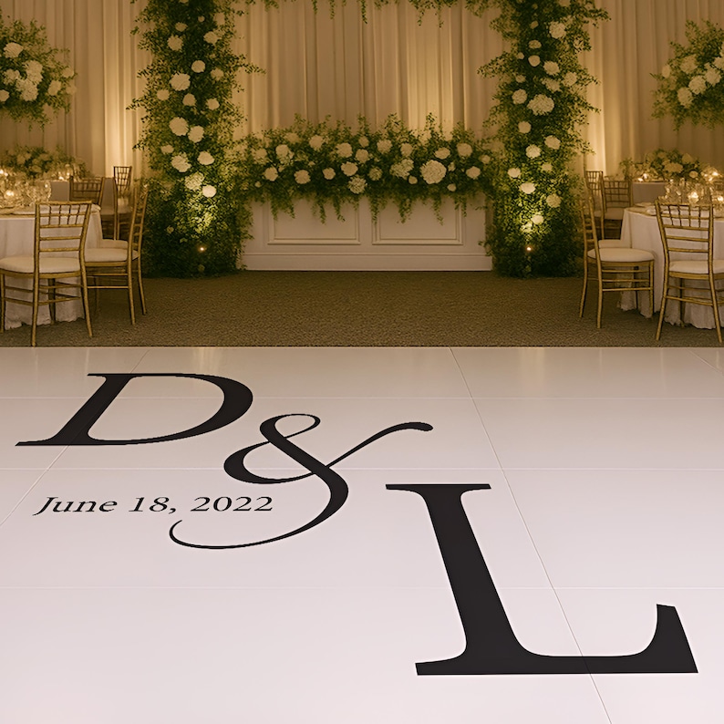 Puede incluir: Una pista de baile blanca con letras negras que dicen "D & L" y "18 de junio de 2022". El fondo presenta un escenario de recepci&oacute;n de boda con arreglos florales y mesas.