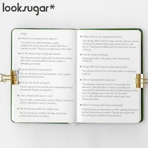 Puede incluir: Un bloc de notas verde con clips dorados, que presenta preguntas frecuentes sobre las calcoman&iacute;as Looksugar. El texto describe la composici&oacute;n, aplicaci&oacute;n, eliminaci&oacute;n y opciones de personalizaci&oacute;n de las calcoman&iacute;as. Las calcoman&iacute;as est&aacute;n hechas en EE. UU. y son aptas para exteriores.