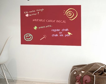 May include: A red writable chalk decal on a white wall. The decal has the text "Kids make things better!" and "WRITABLE CHALK DECAL". It works with regular chalk or chalk ink pens. The decal has a sun, a smiley face, and other illustrations.