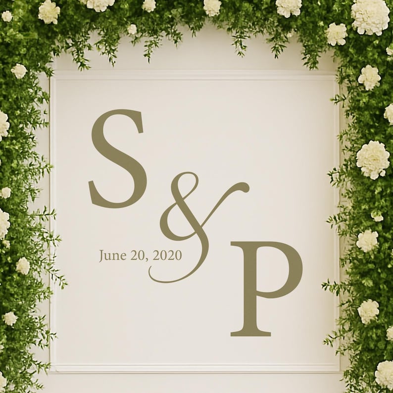 Puede incluir: Un letrero color crema con las iniciales "S & P" y la fecha "20 de junio de 2020" en un suave tono verde. El letrero est&aacute; enmarcado por una exuberante disposici&oacute;n de vegetaci&oacute;n y flores blancas, creando una est&eacute;tica natural y elegante.