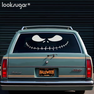 May include: A teal green station wagon with a white Jack Skellington face decal on the rear window. The car has a number plate that reads "HALLOWEEN" with the state of "HALASEIN".