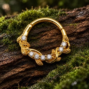 Könnte beinhalten: Ein goldener Ring mit einem dekorativen Weinrankenmotiv, geformten Blättern und sechs klaren, rund geschliffenen Steinen, die entlang des gebogenen Bandes eingelassen sind. Das Metall hat eine polierte Oberfläche und ein Klappsegment.