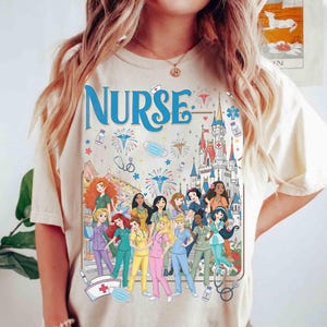 May include: Cream-colored t-shirt with the word "NURSE" in blue script. The shirt features a graphic of various cartoon nurses and a castle, with medical symbols like stethoscopes and face masks.