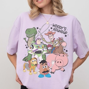 May include: A white ceramic mug with a black handle and the text "But First, Coffee" in a bold, black font. The mug is sitting on a wooden surface. The mug is approximately 4 inches tall.