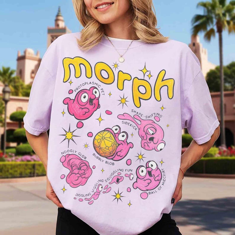 May include: A lilac t-shirt with the word "Morph" in yellow, featuring cartoon pink blob characters with labels such as "Protoplasmic Pet" and "Shape-shifting Sidekick". The design includes yellow star accents.