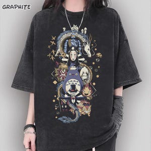 May include: Graphite-colored oversized t-shirt featuring a colorful graphic of anime characters. The design includes a dragon, Totoro, and other figures. The shirt has short sleeves and a relaxed fit, perfect for casual wear.