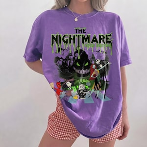 May include: A purple t-shirt featuring a graphic from "The Nightmare Before Christmas." The design includes the title in green dripping font, along with characters like Jack Skellington and Sally. The shirt has short sleeves.