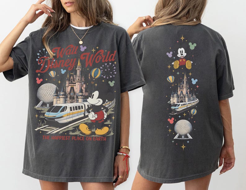 Pu&ograve; includere: Una t-shirt grigio antracite con una stampa grafica di Topolino, una monorotaia, un castello e la sfera di Epcot. Il davanti mostra il testo Walt Disney World e The Happiest Place On Earth. Il retro presenta una disposizione verticale delle icone.