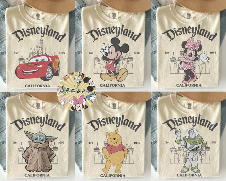 May include: Cream-colored t-shirts featuring Disneyland graphics. Designs include Lightning McQueen, Mickey Mouse, Minnie Mouse, Grogu, Winnie the Pooh, and Buzz Lightyear. Each shirt has the Disneyland logo and "California" printed on it.